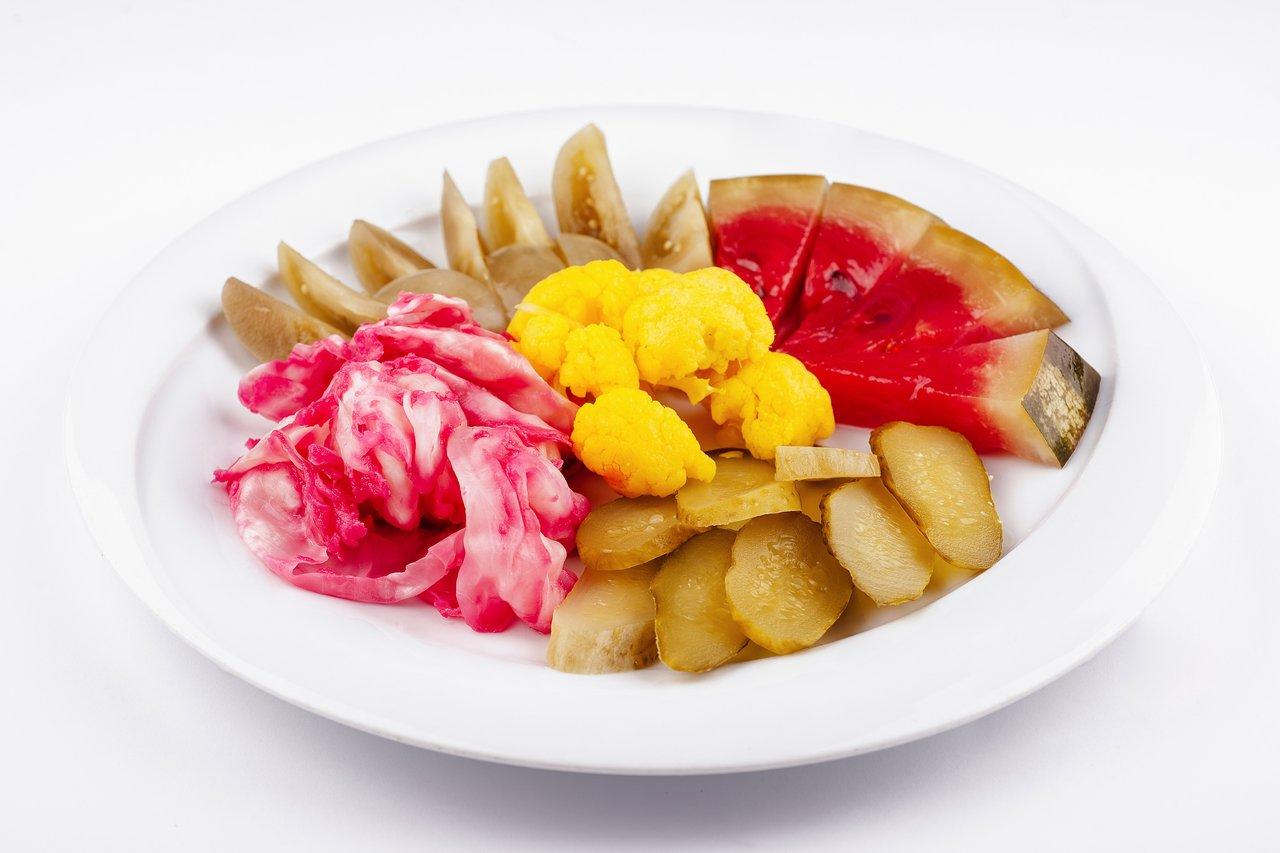 Assiette colorée de aliments fermentés riches en probiotiques pour renforcer l'immunité hivernale.