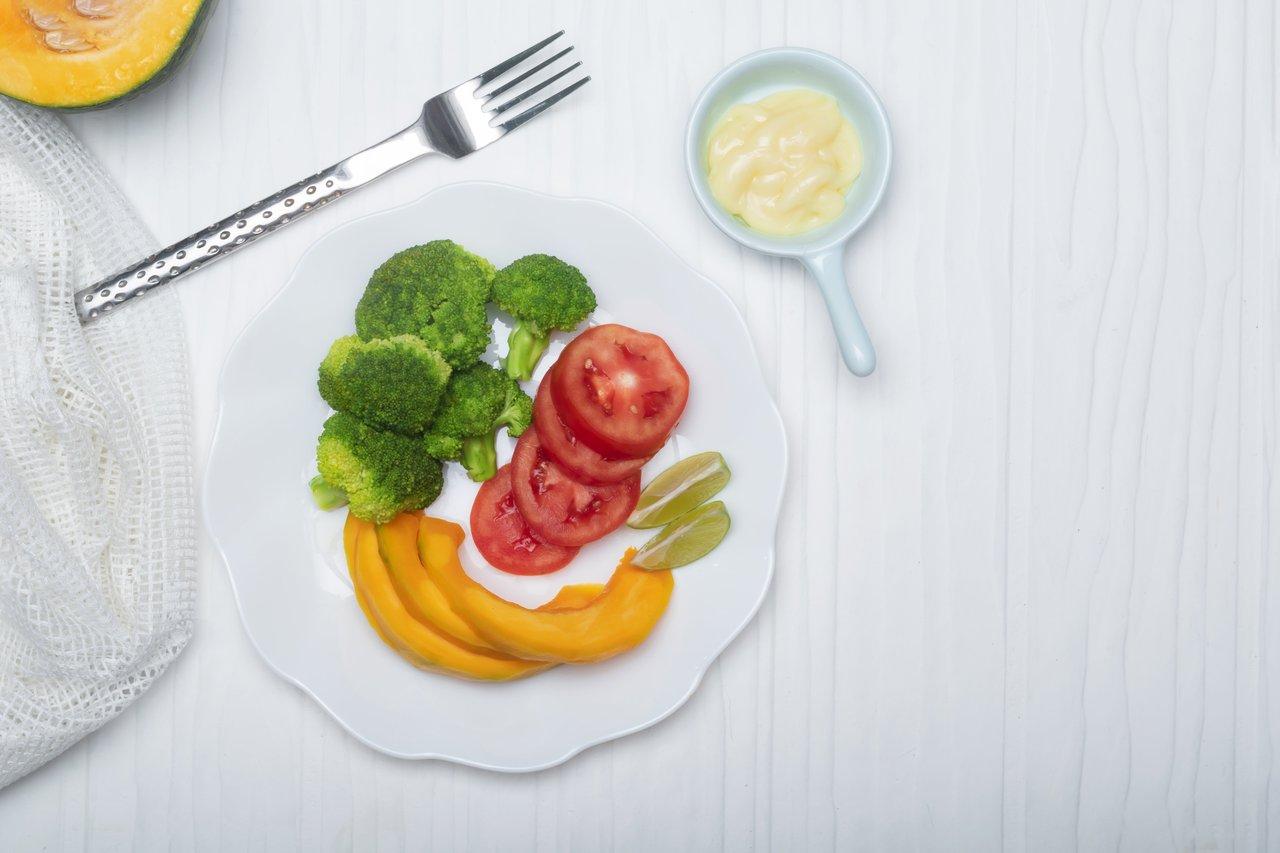 Assiette de healthy food avec brocoli, tomate et courge, idéale pour un repas sans sucres ajoutés.