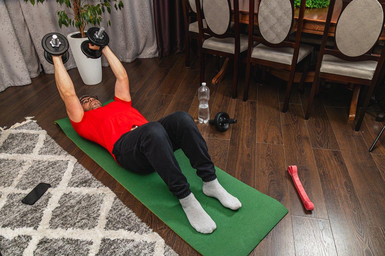 Circuit training maison avec haltères, corde à sauter et chaise pour un entraînement cardio et musculation efficace.