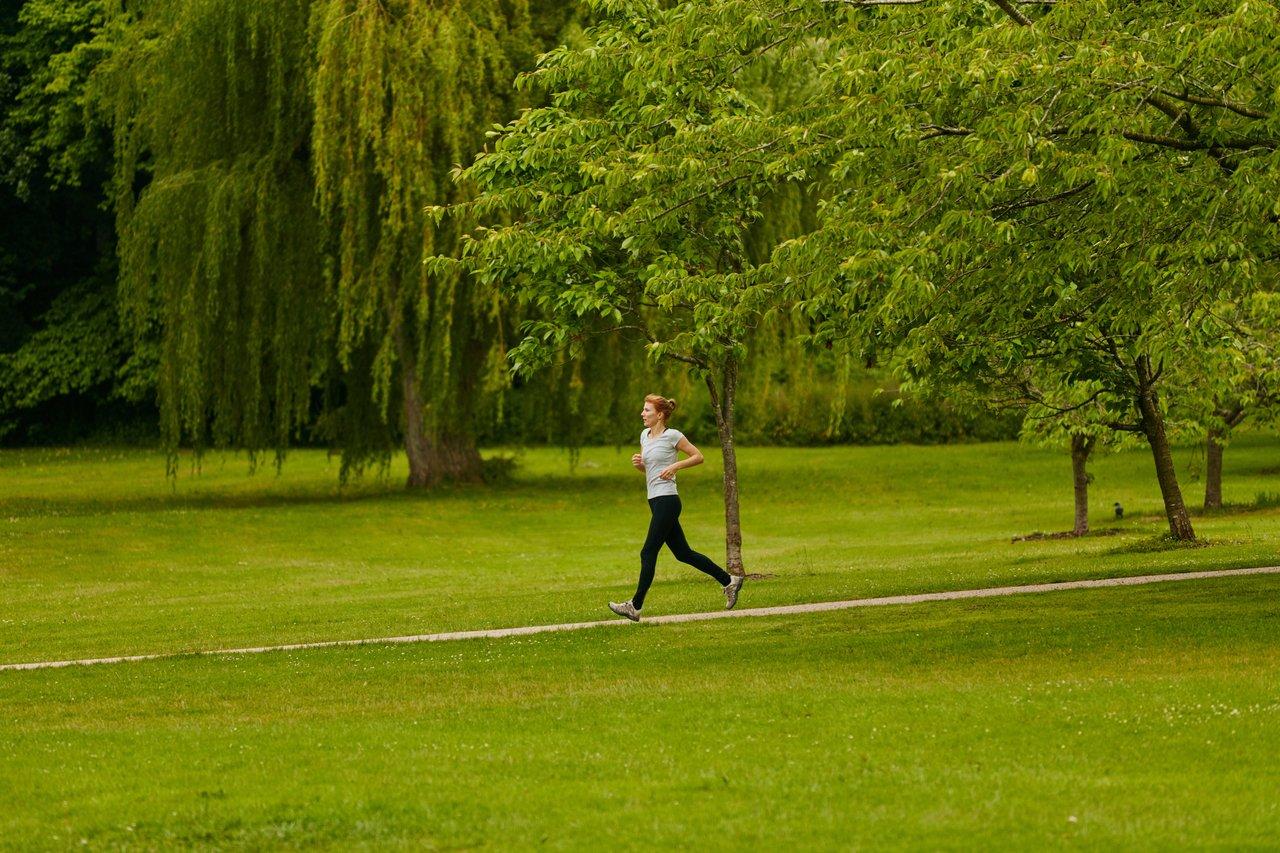 Coureur débutant effectuant un entraînement fractionné dans un parc printanier avec un équipement basique.