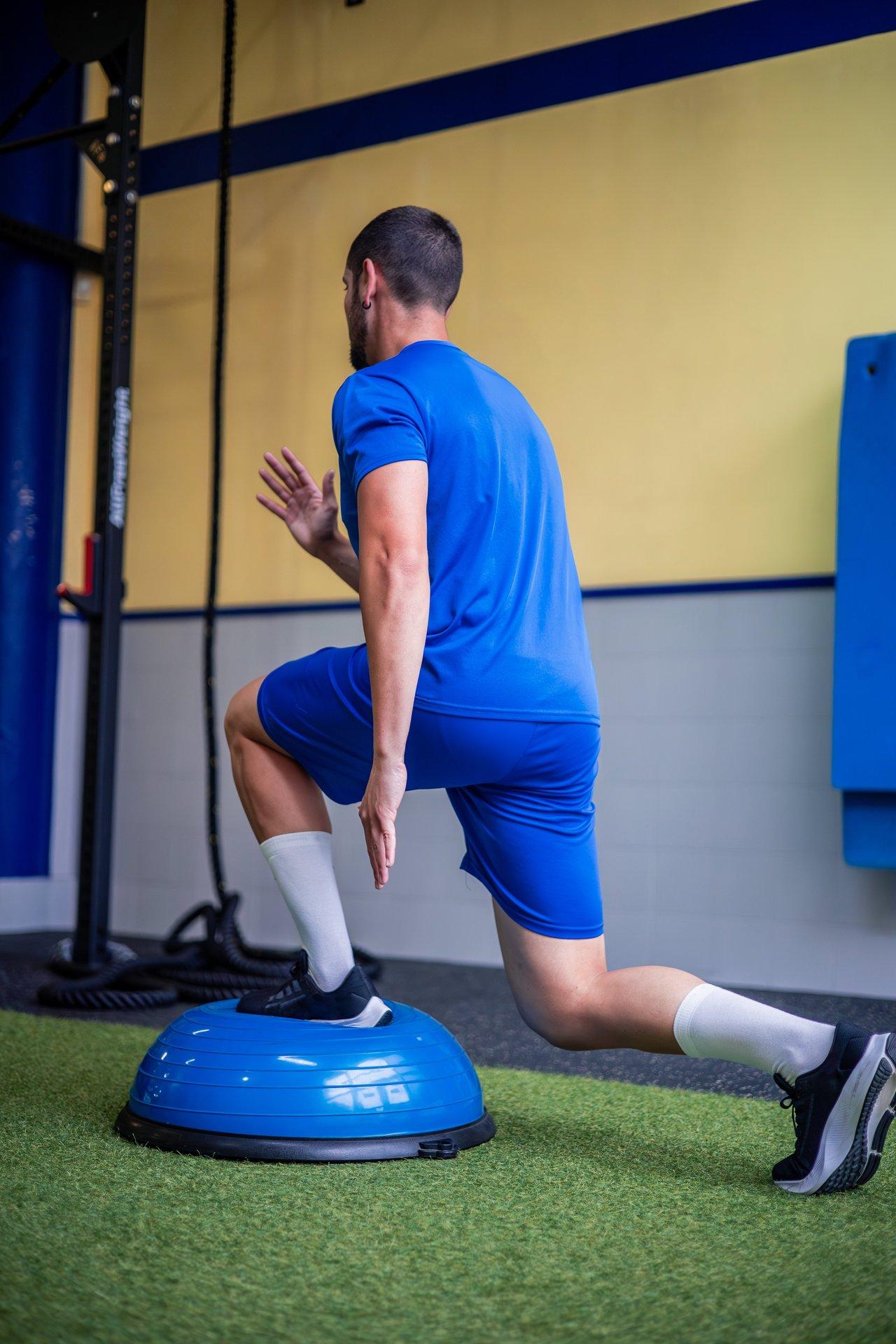 Échauffement dynamique des jambes en salle de sport pour préserver ses articulations et optimiser l'entraînement.