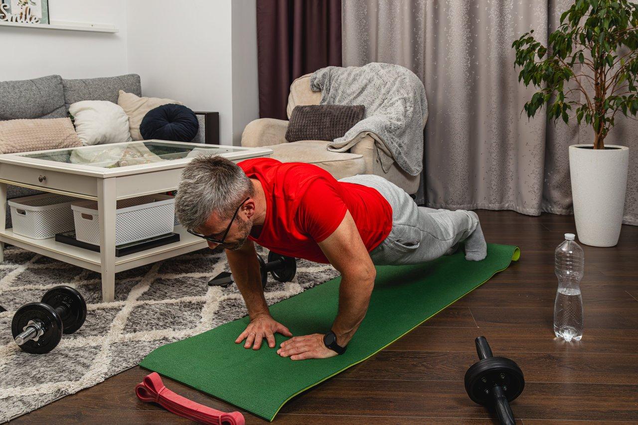 Exercice de bodyweight workout dans le salon pour tonifier l'ensemble du corps sans matériel.