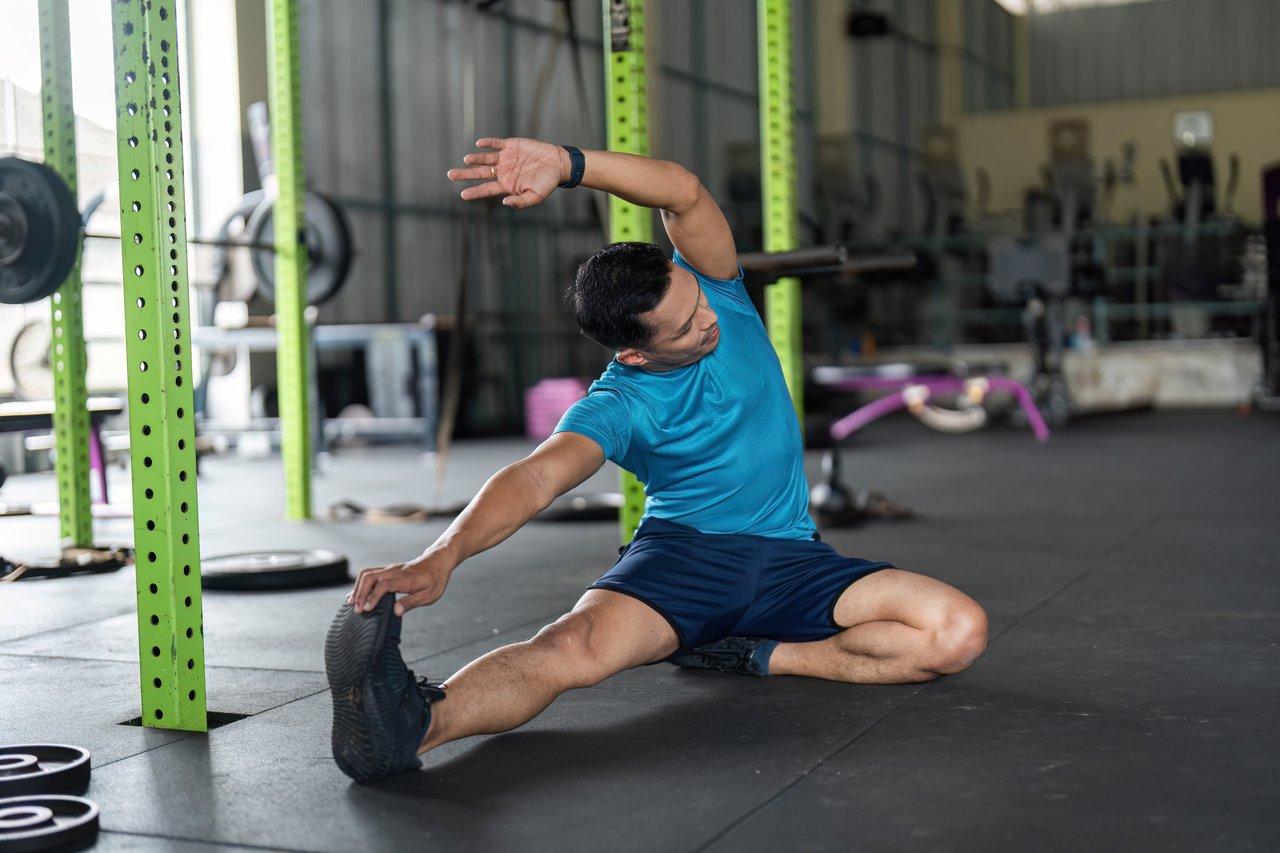 Exercice de mobilité articulaire dynamique au sol pour améliorer la flexibilité et le bien-être.