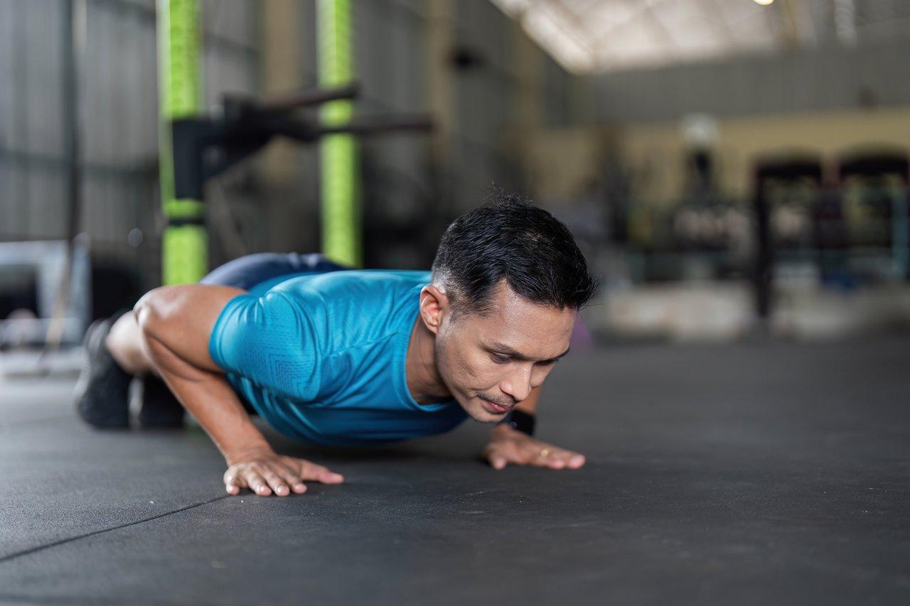 Exercice d'elevated push-up workout pour renforcer la silhouette dans un espace de fitness à domicile.