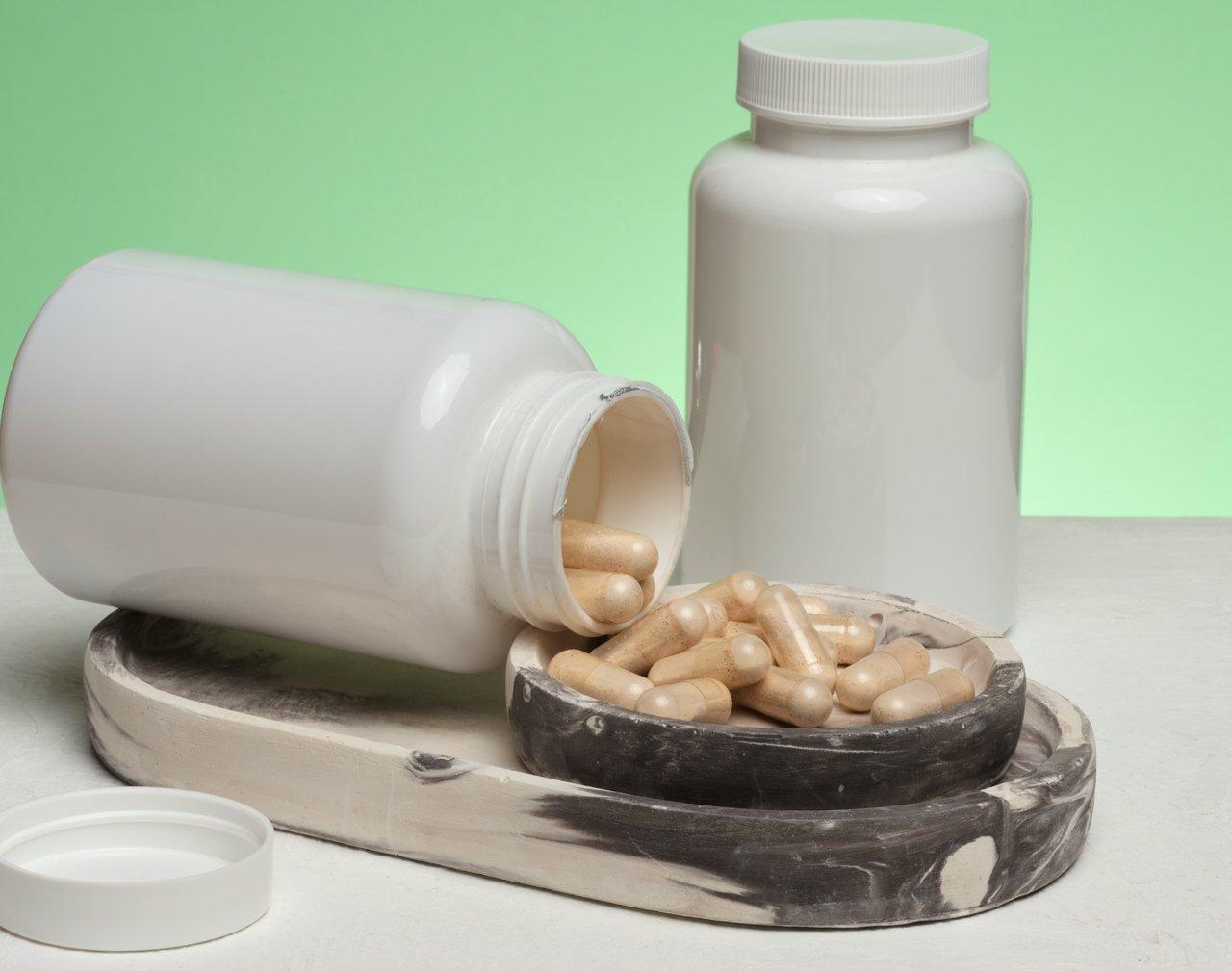 Flacons de compléments naturels pour le soulagement du stress, incluant magnésium, ashwagandha et vitamines, sur fond apaisant.