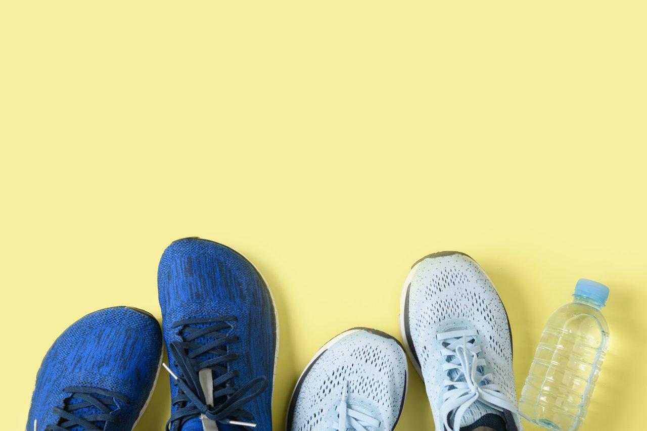 Jeune adulte choisissant des chaussures de sport adaptées pour la course à pied dans un magasin spécialisé.