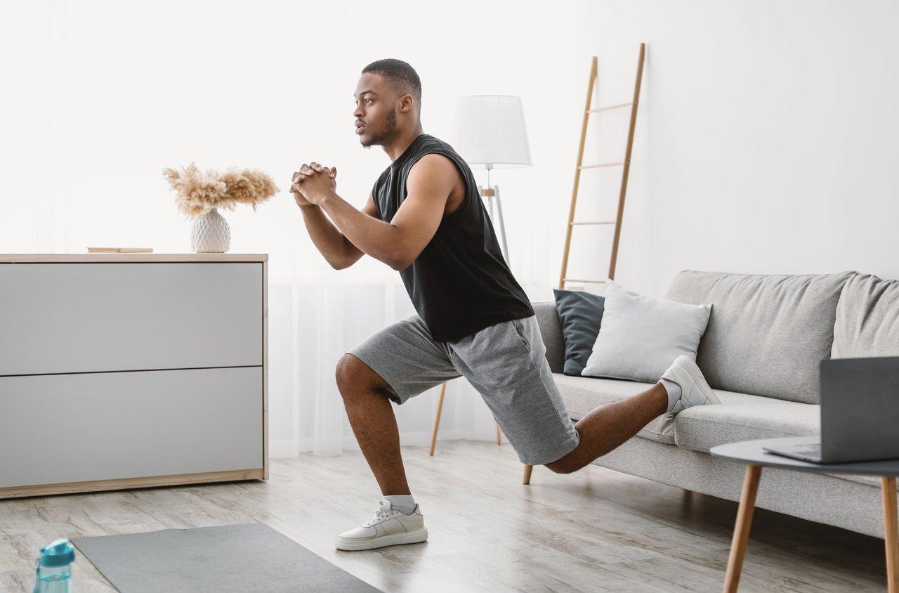 Personne réalisant un Bulgarian split squat à la maison pour renforcer les fessiers efficacement.