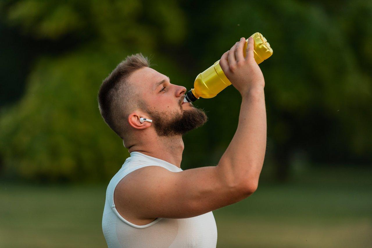 Runner en pleine course avec hydratation et compléments naturels pour booster l'endurance.