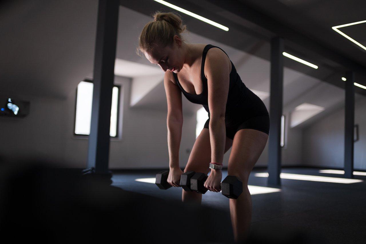 Séance de dumbbell circuit training pour gagner en force en 6 semaines dans un espace d’entraînement moderne.