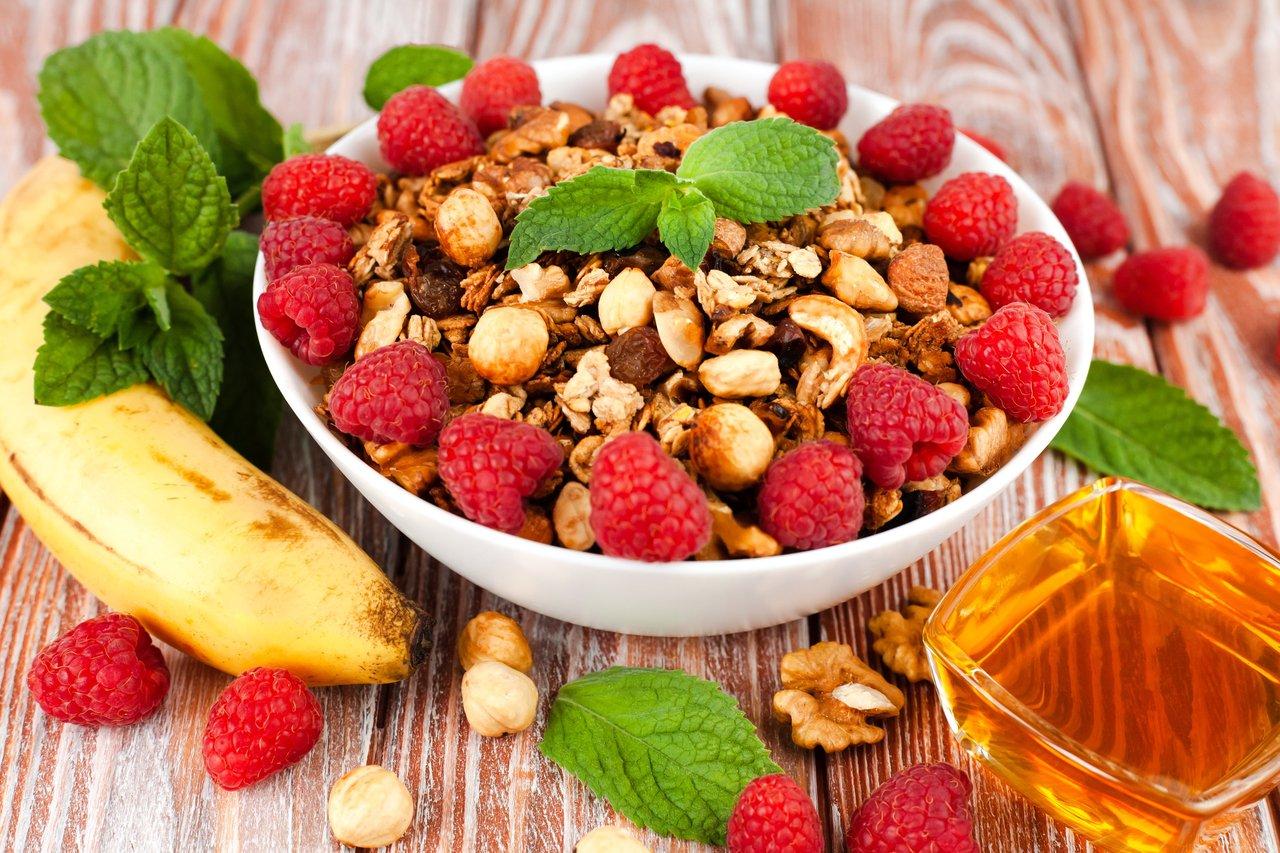 Un athlete healthy breakfast avec granola, fruits et miel pour optimiser ses performances sportives.