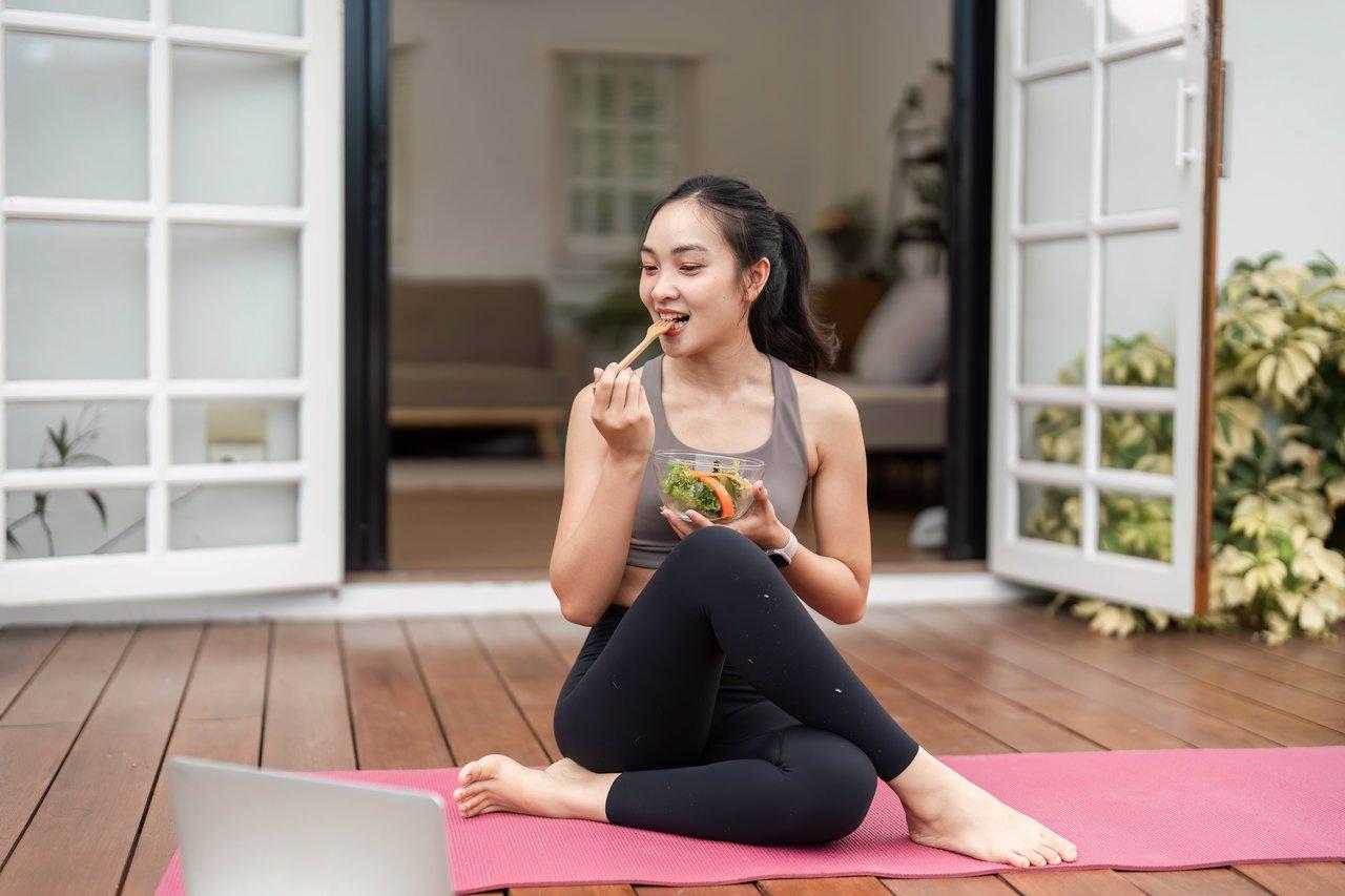Une femme pratiquant le mindful eating meal, dégustant lentement un repas sain sans distractions.