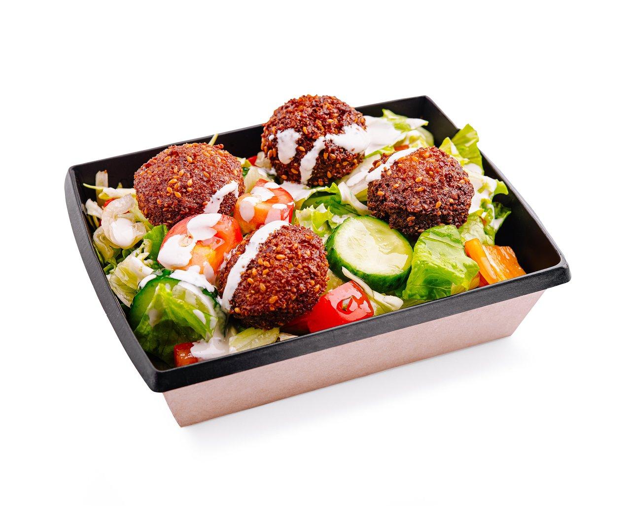 Une lunch box saine avec quinoa, légumes rôtis et falafels pour un déjeuner équilibré.