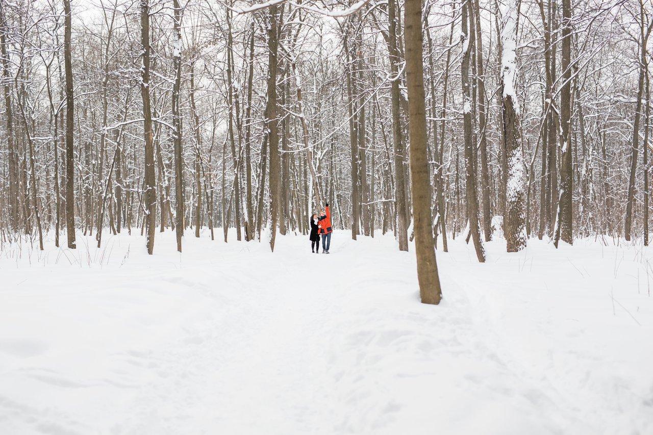 Une personne en tenue adaptée pratiquant la winter brisk walking dans un parc enneigé, idéale pour booster son immunité.
